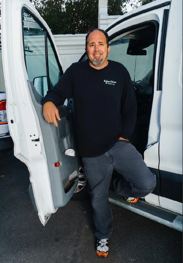 Charles McHenry, owner of Alliance Chimney & Energy, standing by the work van