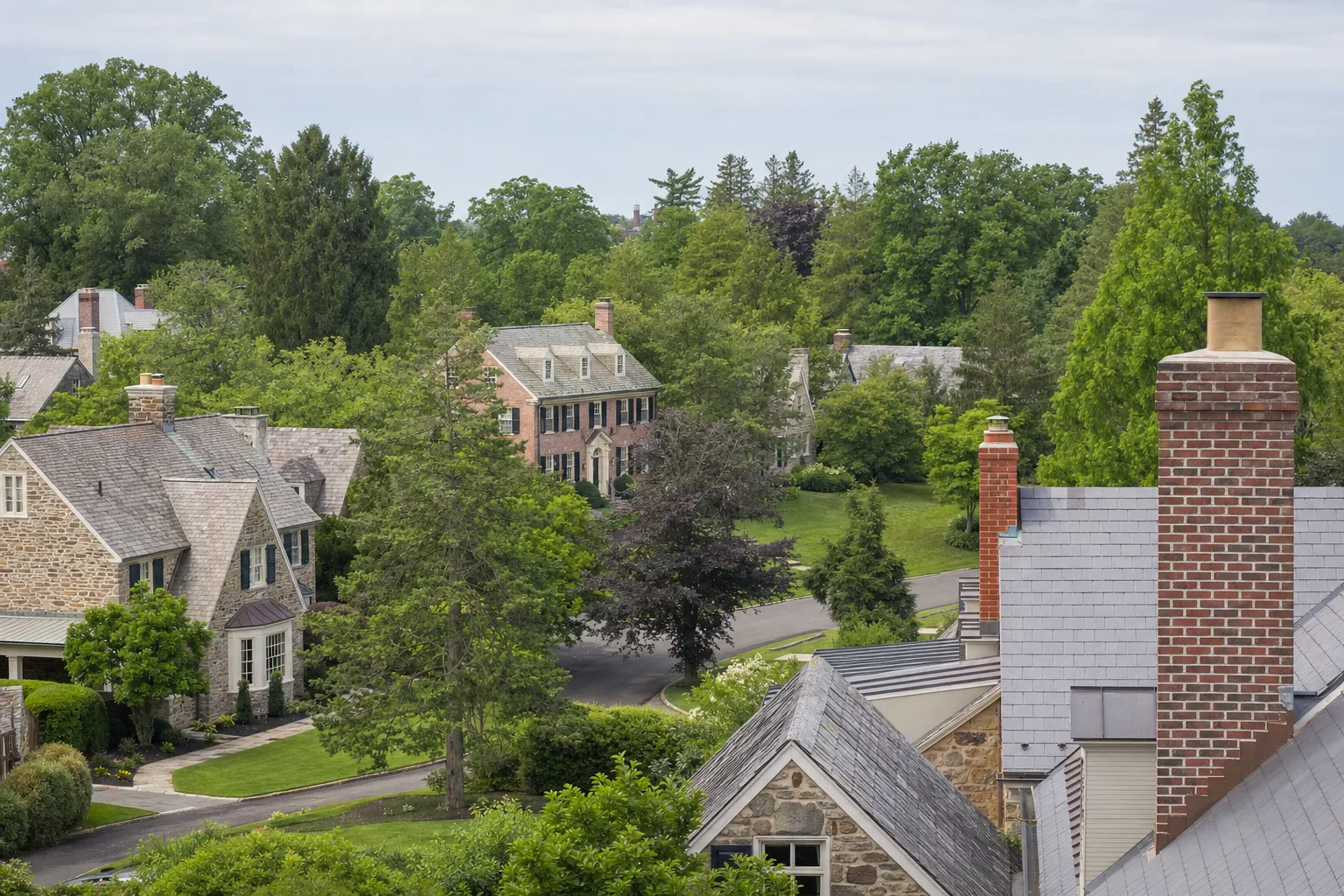 Golden-hour view over a Main Line, PA neighborhood of historic stone homes served by Alliance Chimney & Energy